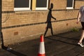 Shadow of a walking boy on brick building wall