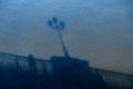 The shadow on the water of a man standing on a bridge next to the handrail Royalty Free Stock Photo