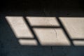 Shadow of window with grill by sun light coming from window during morning time on the tile Royalty Free Stock Photo