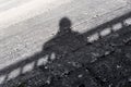 Shadow of a woman leaning over the railing of a concrete bridge Royalty Free Stock Photo