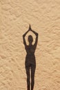 shadow of woman meditates and does yoga on sandy beach, sports and fitness silhouettes Royalty Free Stock Photo