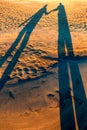 Shadow of a young couple on a sandy beach Royalty Free Stock Photo