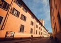 Shadows on buildings in the ancient Tuscany city with walking people between the old houses Royalty Free Stock Photo