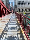 Shadows create patterns on the LaSalle St bridge which is covered with rain puddles, & where commuters rush home