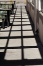 Shadows forming geometric grid pattern on walkway under sunlight creating abstract urban outdoor visual composition Royalty Free Stock Photo
