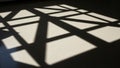 Shadows with geometric patterns are cast on a light colored terrazzo floor Royalty Free Stock Photo