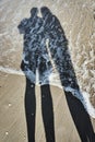 Shadows of man and woman on a sandy beach