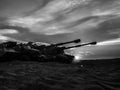 Shadows of military tanks at night at sunset