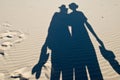 Shadows of pair of tourists on sand