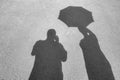 Shadows on the pavement. Male shadow and the shadow of a woman with an opened umbrella