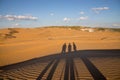 Shadows of people in XiangshaWan, or Singing sand Bay, in hobq or kubuqi desert, Inner Mongolia, China during sunset