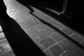 Shadows stretching across stone tiled floor in black and white Royalty Free Stock Photo