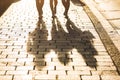 Shadows of three girls walking on a sidewalk in the city