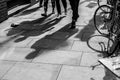 Shadows of three walking pedestrians projected on the sidewalk Royalty Free Stock Photo