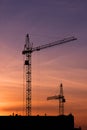 Shadows of two construction cranes on a sunset background Royalty Free Stock Photo