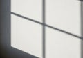 Shadows from a window pane create a grid pattern on a white wall. The lines are soft Royalty Free Stock Photo