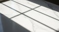 Shadows of window panes cast on a white marble surface, characterized by subtle gray veining. The Royalty Free Stock Photo