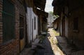 Shady alleyway between dilapidated old houses in sunny summer