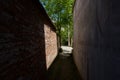Shady alleyway between old buildings in sunny spring