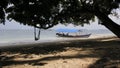 SHADY BEACH SHADED BY SHADY TREES AND TRADITIONAL WOODEN FISHING BOATS ARE LEANING ON THE BEACH