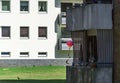 Shady dark settlement with terraced houses in a suburb, with a bright colorful toy balloon on an ugly dirty old balcony