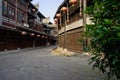 Shady flagstone-paved street between old-fashioned buildings in Royalty Free Stock Photo