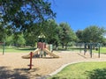 Shady from large trees and colorful urban playground at public park in downtown Dallas, Texas, USA Royalty Free Stock Photo