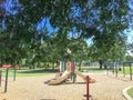 Shady from large trees and colorful urban playground at public park in downtown Dallas, Texas, USA Royalty Free Stock Photo