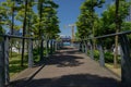 Shady planked footbridge in modern city of sunny summer