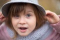 Shaggy girl in jacket, gray scarf and fedora hat