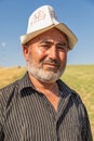 Man wearing a traditional hat in a field during harvest