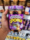 SHAH ALAM, MALAYSIA - 8 October 2020 : Hand hold a jar of SMUCKERS Goober Grape peanut butter for sell in the supermarket.