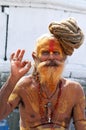 Shaiva sadhu seeking alms in front of a temple