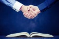 Shake hands on open books Royalty Free Stock Photo