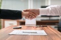 Shakehand of lawyer and business woman sitting behind desk with agreement Royalty Free Stock Photo