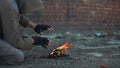 Homeless man warms his hands. Hands in black torn gloves Close up. Post-apocalypse scene