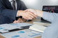 Shaking Hand between businessman of cooperation over Stock market chart, business trading concept Royalty Free Stock Photo