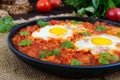 Shakshuka - a dish of eggs fried in a sauce of tomatoes, hot pepper, onions and seasonings.