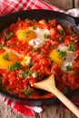 shakshuka fried eggs with sauce close up in a frying pan. Vertical