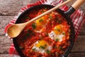 Shakshuka of fried eggs with tomato sauce in a pan close-up. horizontal top view Royalty Free Stock Photo