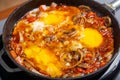 Shakshuka with herbs in a frying pan on a gray background.close-up. Royalty Free Stock Photo