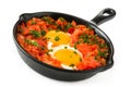 Shakshuka in iron frying pan isolated on white background.