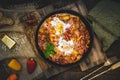 Shakshuka in an iron pan on wooden background Royalty Free Stock Photo