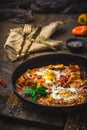Shakshuka in an iron pan on wooden background Royalty Free Stock Photo
