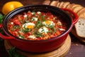 shakshuka in a red enamel pot with a wooden spoon Royalty Free Stock Photo