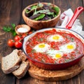 Shakshuka with tomatoes and eggs in a cast iron pan