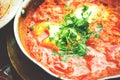 Shakshuka. Traditional jewish food and middle eastern cuisine recipe. Fried eggs, tomatoes, bell pepper and parsley in a Royalty Free Stock Photo