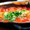 Shakshuka. Traditional jewish food and middle eastern cuisine recipe. Fried eggs, tomatoes, bell pepper and parsley in a Royalty Free Stock Photo