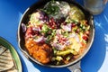Shaksouka Hola Mexico. Eggs baked in aromatic tomato and peppers paste, with beans, served with marinated cactus, guacamole, salsa