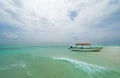 Shallow atoll sandbanks turquoise waves with lonely pleasure boat around Mnemba island in the Indian Ocean near the Zanzibar